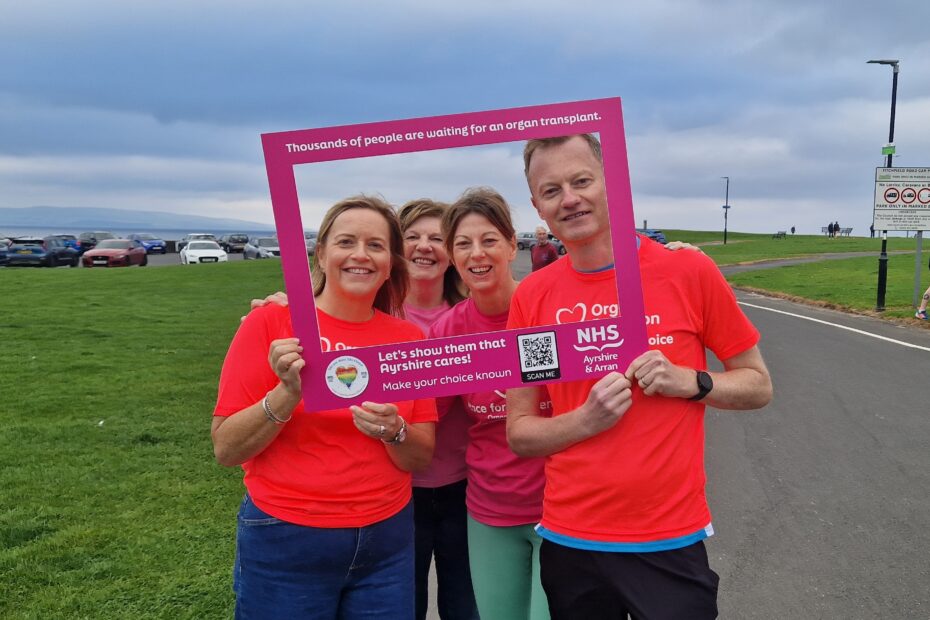 NHS Ayrshire & Aran staff, wearing organ and tissue donation t- shirts and standing behind a selfie frame at Troon parkrun race.